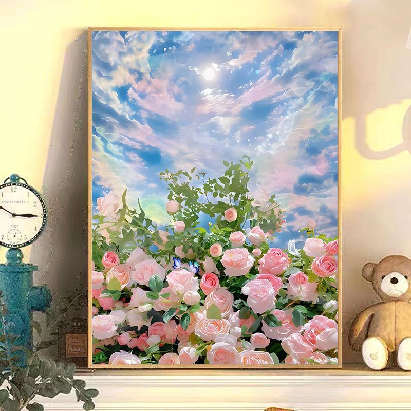Framed artwork of pink flowers and a blue sky with clouds, displayed on a wall with decorative items.