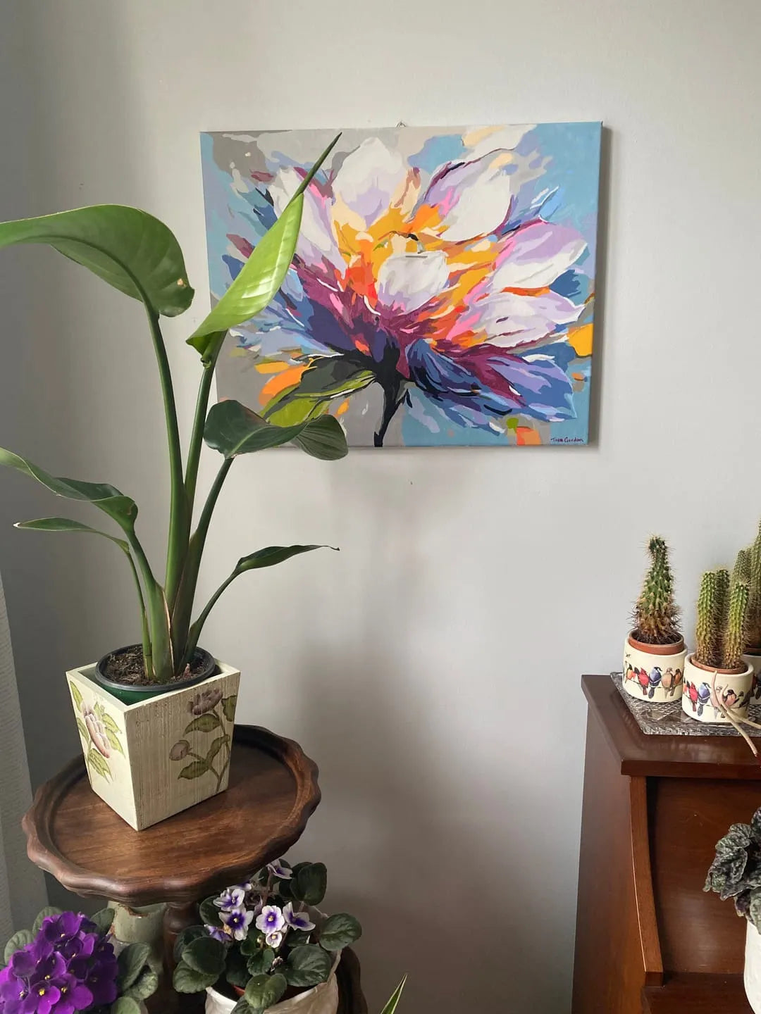 Customer's finished paint by numbers floral painting hung on a living-room wall