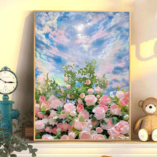 Framed artwork of pink flowers and a blue sky with clouds, displayed on a wall with decorative items.