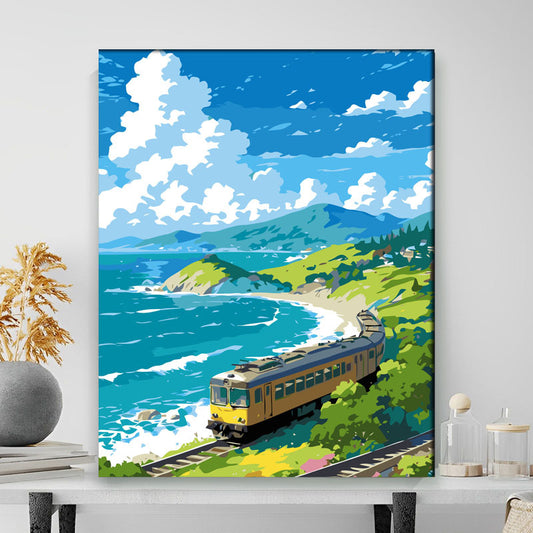 Framed artwork of a train on tracks near a coastal landscape with mountains.