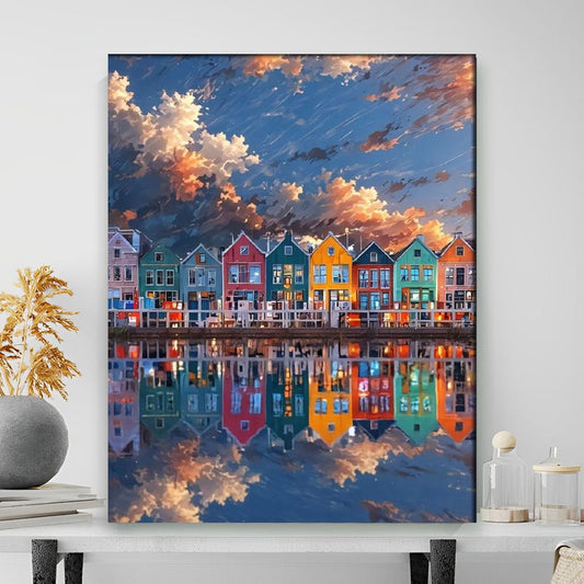 Framed artwork of colorful houses reflected in water with a blue sky.