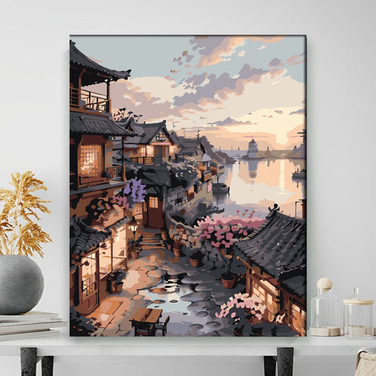 Framed artwork of a traditional Japanese village scene with cherry blossoms and a bridge.