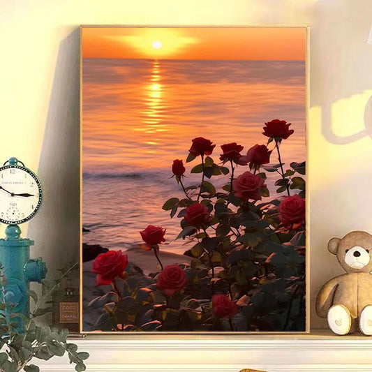 Framed artwork of red roses with a sunset over water scene, placed on a shelf with decorative items.